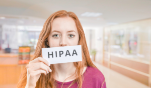 HIPAA law - A woman holding up a sign in front of her face which reads "HIPAA"