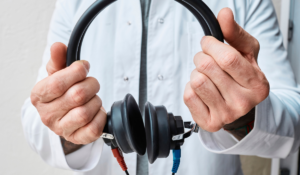 Somebody holding up the type of headphones used in a workplace hearing test