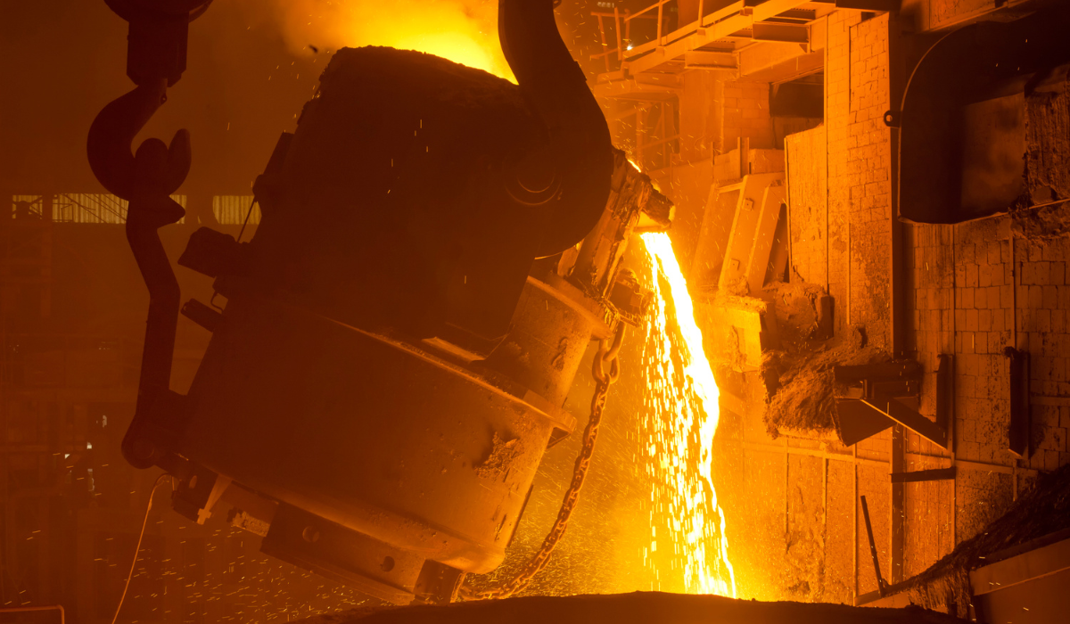 A large kiln of molten metal being poured into molds