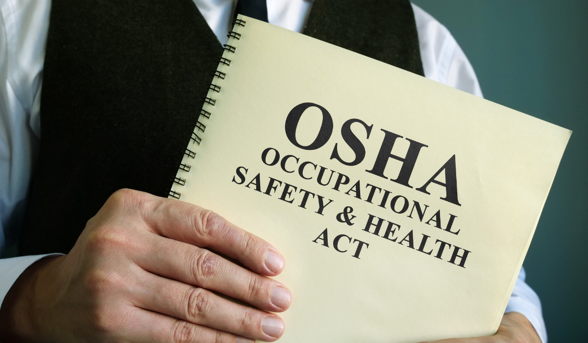 A person presumed to be a doctor holding a paper which reads "occupational safety & health act, OSHA"